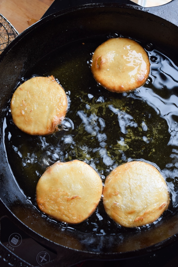Frying doughnuts in a pan of oil.