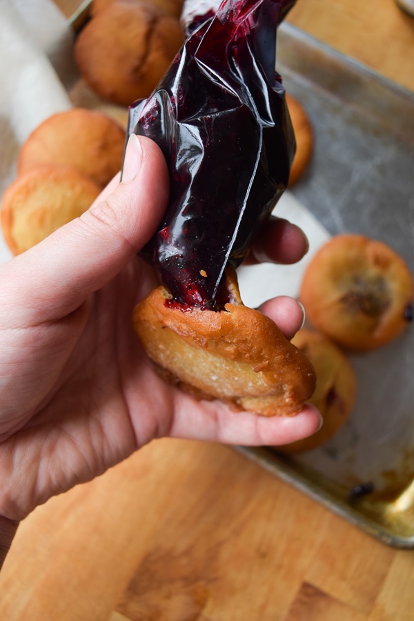Adding jelly into a freshly made doughnut.