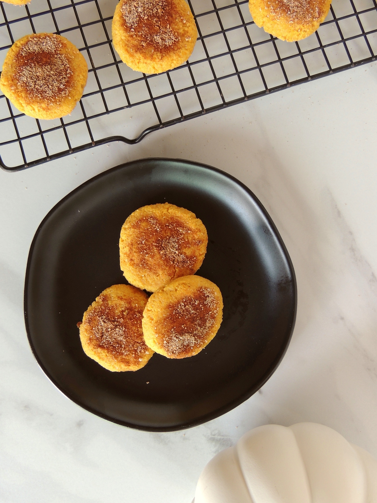 Cover image for gluten free keto pumpkin cookies - overhead view of 3 cookies on a black plate.