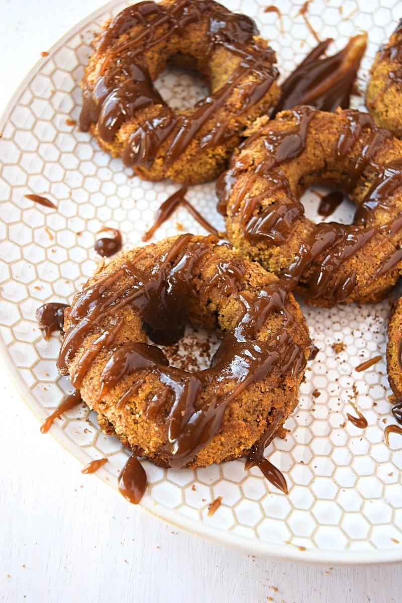 Cover image of gluten free paleo pumpkin doughnuts - features doughnuts on a white plate.