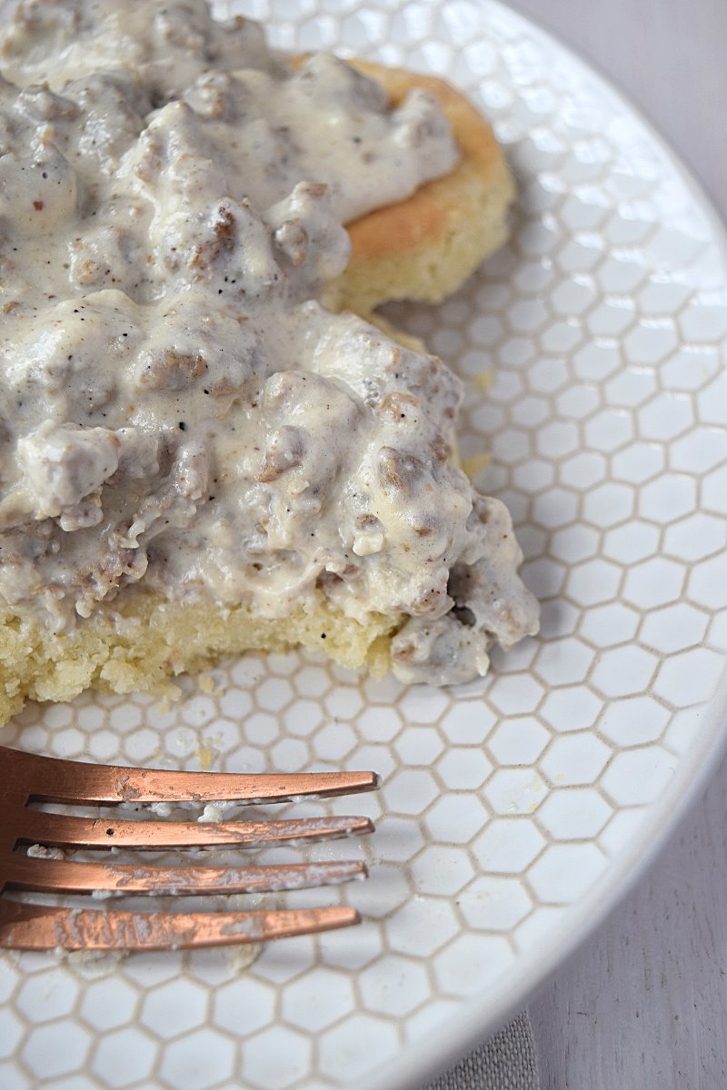 A biscuit and gravy with a bite missing