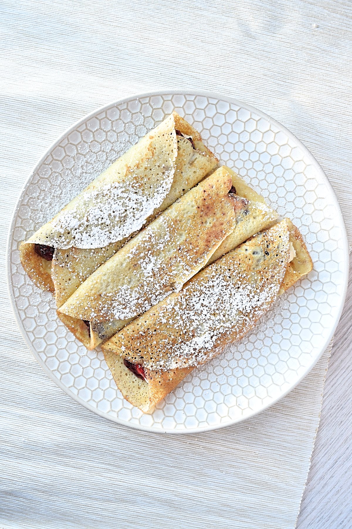 Gluten free blintzes sitting on a white plate.