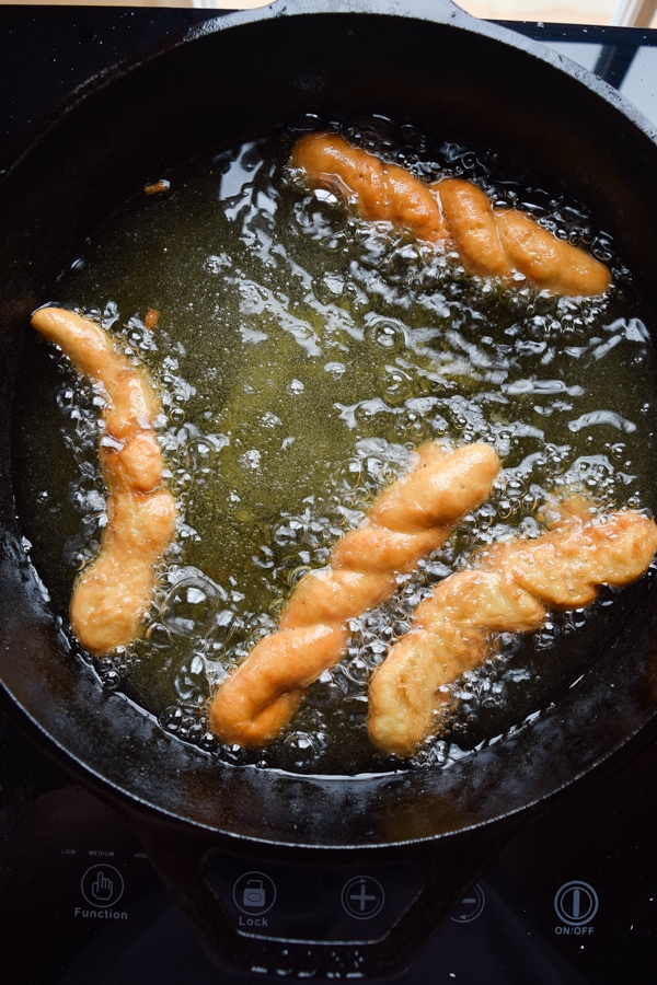 Frying gluten free cinnamon twists.