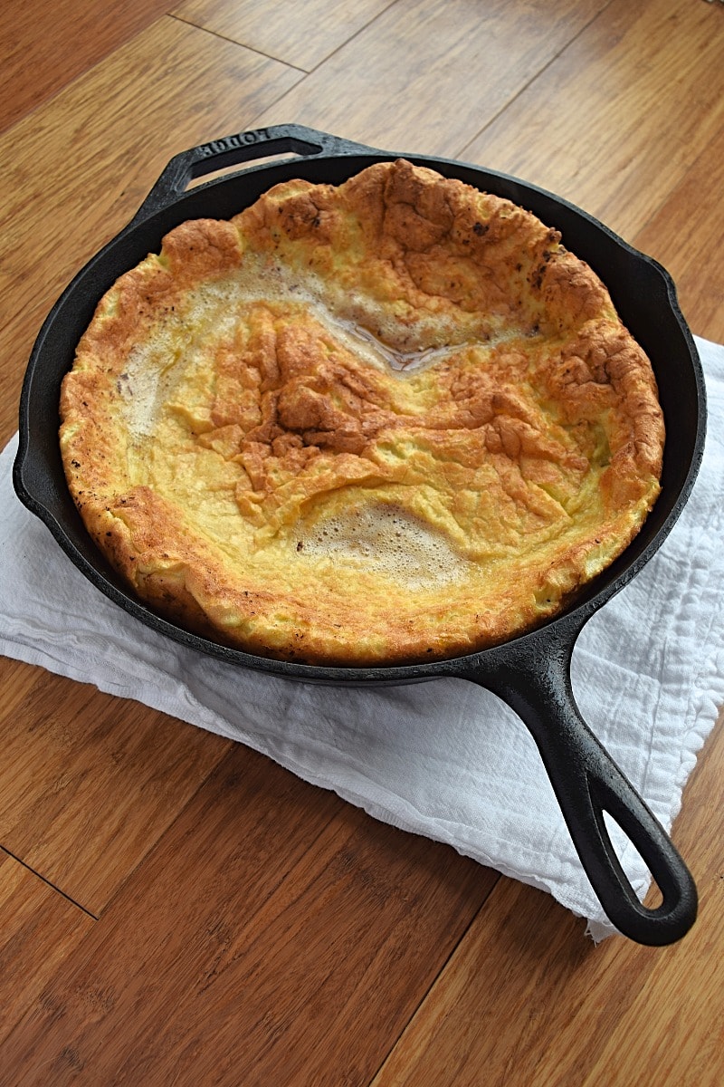 Cover image for gluten free dutch baby blog post. Features a freshly cooked German pancake in a cast iron pan.