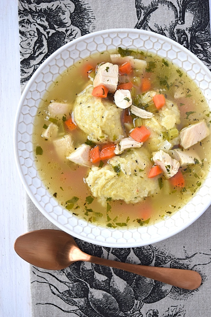 a bowl of gluten free chicken dumpling soup with a spoon