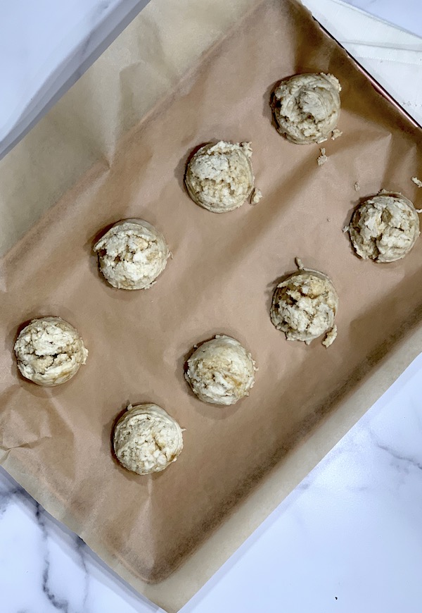 easy scones without butter dished out before baking on a brown parchment lined cookie sheet