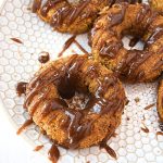 Cover image of gluten free paleo pumpkin doughnuts - features doughnuts on a white plate.
