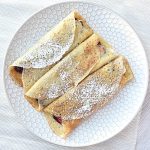 Gluten free blintzes sitting on a white plate.