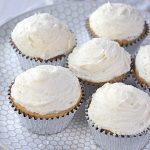 Cover image for gluten free vanilla cupcakes post - features fresh-baked vanilla cupcakes on a white plate.