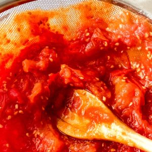 Crushed tomatoes being stirred